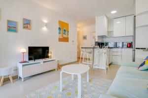 a living room with a couch and a table and a kitchen at "L'Idyllique" Parking, Piscine, Plage, Calme assuré, Gare in Roquebrune-Cap-Martin