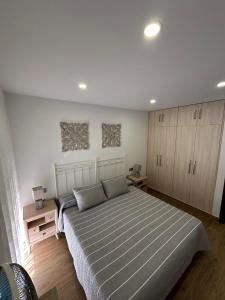 a bedroom with a large bed and wooden floors at apartamento la perla in Fuengirola