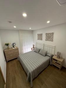 a bedroom with a bed and a dresser and a window at apartamento la perla in Fuengirola