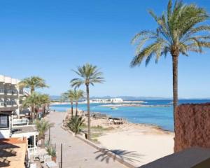 a view of a beach with palm trees and the ocean at APT Borras & Roca Plana, fronte mare in Es Pujols