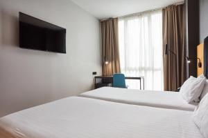 A bed or beds in a room at Silken Sant Gervasi