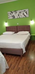 1 dormitorio con 1 cama grande y pared verde en Apartment Garden (112-3), en Medulin