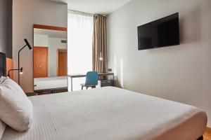 A bed or beds in a room at Silken Sant Gervasi