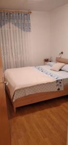 a bed in a bedroom with a white curtain at Apartment Medulin (112-1) in Medulin
