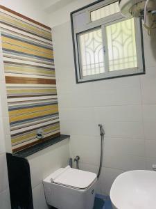 La salle de bains est pourvue de toilettes et d'une fenêtre. dans l'établissement The white yard stays, à Varanasi
