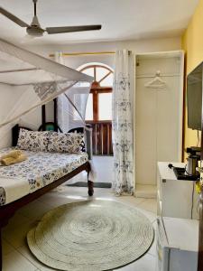 - une chambre avec des lits superposés et une fenêtre dans l'établissement Kelele Square, à Zanzibar City