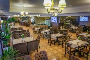 - un restaurant avec des tables et des chaises dans une salle dans l'établissement Premier Hotel Palazzo, à Poltava