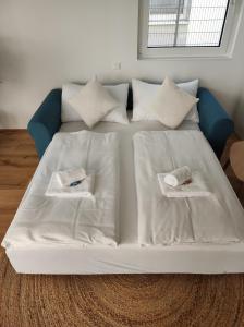 a white bed with pillows and towels on it at Roksox-home Apartment gegenüber der Uno-City und Kaiserwasser in Vienna