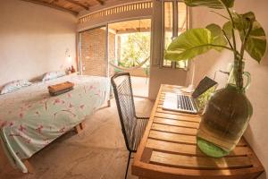 a bedroom with a table with a laptop and a plant at Casa Aquila Mazunte in Mazunte