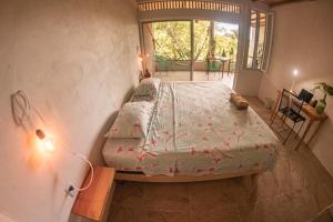 a bedroom with a bed in a room with a window at Casa Aquila Mazunte in Mazunte