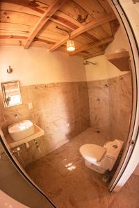 a bathroom with a sink and a toilet and a mirror at Casa Aquila Mazunte in Mazunte