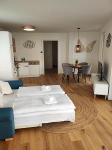 ein Schlafzimmer mit einem weißen Bett und ein Wohnzimmer in der Unterkunft Roksox-home Apartment gegenüber der Uno-City und Kaiserwasser in Wien