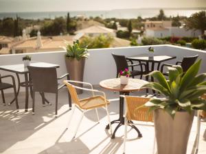 un patio con mesas y sillas en el balcón en Amigos para Sempre - Casa de Hóspedes, en Ferragudo