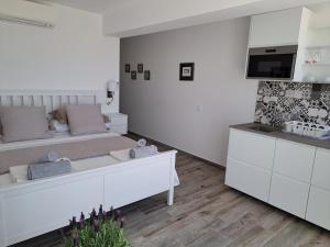 Amigos para Sempre - Casa de Hóspedes في فيريغودو: غرفة نوم بيضاء مع سرير وتلفزيون