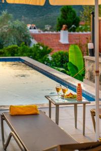 una mesa con dos copas de vino junto a una piscina en Kaya Apartments Kalamar, en Kalkan