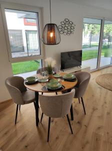 a dining room with a table and chairs and a television at Roksox-home Apartment gegenüber der Uno-City und Kaiserwasser in Vienna