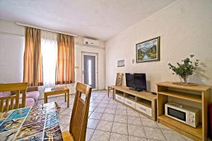 a living room with a television and a dining table at Apartments Villa Marija in Podobuče