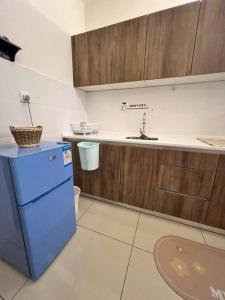 een keuken met een blauwe koelkast en een wastafel bij Lily Fair ~ Cameron Highlands in Tanah Rata