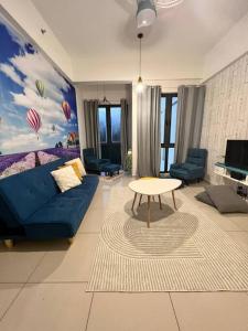 een woonkamer met een blauwe bank en een tafel bij Lily Fair ~ Cameron Highlands in Tanah Rata