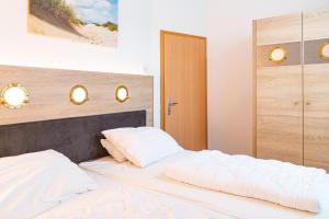 - une chambre avec un lit et 2 oreillers blancs dans l'établissement Hanse Appartement II Warnemünde, à Warnemünde