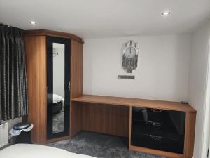 um quarto com uma cómoda e um relógio na parede em Belfast Luxury Apartment em Belfast