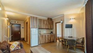 a living room with a table and a kitchen at Orbi Royal Apartments in Batumi