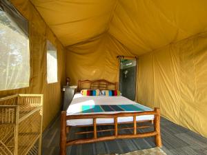 a yellow tent with a bed in it at Sobaway Resorts in Ella