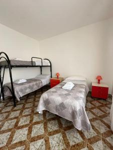 een slaapkamer met 2 stapelbedden en een tegelvloer bij CAMA Casa Vacanze in Palermo