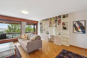 - un salon avec un canapé et une grande fenêtre dans l'établissement Tourelle - Appartement moderne dans le centre de Genève, à Genève