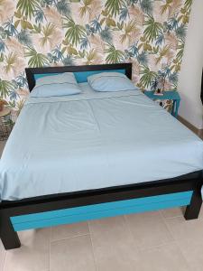 a bed with a blue bed frame in a room at Studio in Challans