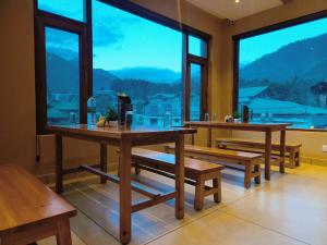 a room with benches and tables and a large window at Sa-Ba Manali Inn, Mall Road in Manāli
