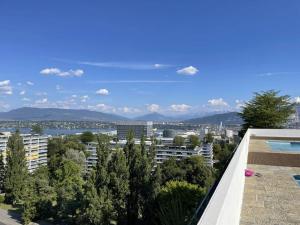 Blick auf eine Stadt vom Dach eines Gebäudes in der Unterkunft Wide, bright and quiet loft in Genf