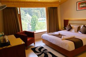 a bedroom with a bed and a large window at Sa-Ba Manali Inn, Mall Road in Manāli