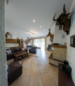 um quarto com uma sala de estar com uma sala de estar com cabeças de animais na parede em Mežnoras holiday house 