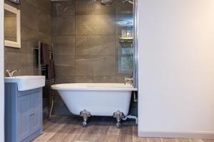 a bathroom with a tub and a sink at Howgills House Hotel in Sedbergh