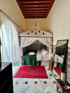 a bedroom with a bed with two pairs of scissors on a rug at Riad Tizwa Marrakech in Marrakesh