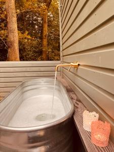 a bath tub with a water faucet and a window at Southfield Shepards Huts in Durham