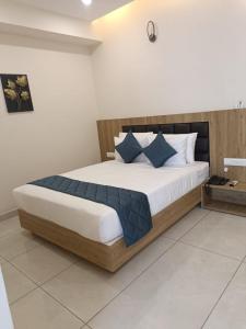 1 dormitorio con 1 cama grande con almohadas azules en SIGNATURE INN, en Chikmagalur