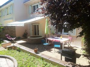 un patio con mesa y sillas frente a una casa en Chambre chez l'habitant. en Metz