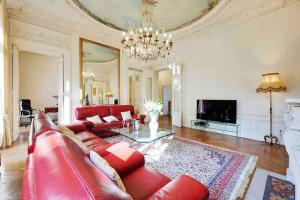 a living room with a red couch and a table at Champs Élysées : Appartement 200 m2 avec balcon in Paris