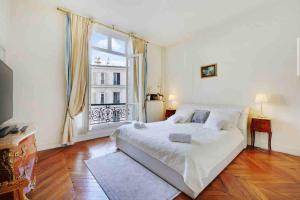 a bedroom with a bed and a large window at Champs Élysées : Appartement 200 m2 avec balcon in Paris