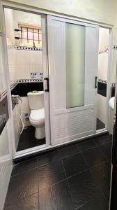La salle de bains est pourvue de toilettes et d'une porte en verre. dans l'établissement Apartment Huz Peer 2, à Trou aux Biches