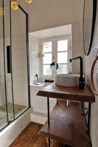 a bathroom with a sink and a shower at La Villa d'Anna, une décoration très tendance ! in Primelin