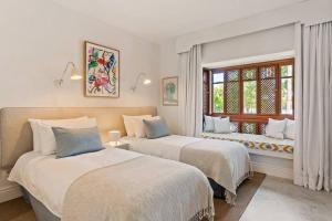 a bedroom with two beds and a window at 2-Bedroom Apartment in Puente Romano, Marbella in Marbella
