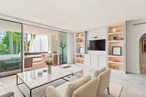 a living room with a glass table and chairs at 2-Bedroom Apartment in Puente Romano, Marbella in Marbella