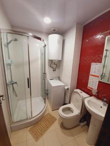 uma casa de banho com um chuveiro, um WC e um lavatório. em Orbi Royal Apartments em Batumi