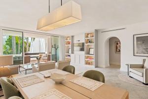 a dining room and living room with a table and chairs at 2-Bedroom Apartment in Puente Romano, Marbella in Marbella