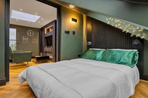 a bedroom with a large bed with a green headboard at Luxury Studio Retreat in London