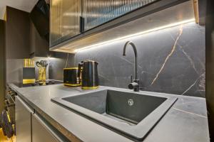 a kitchen sink with a faucet on a counter at Luxury Studio Retreat in London