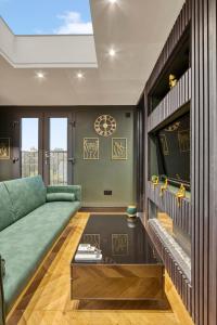 a living room with a green couch and a tv at Luxury Studio Retreat in London